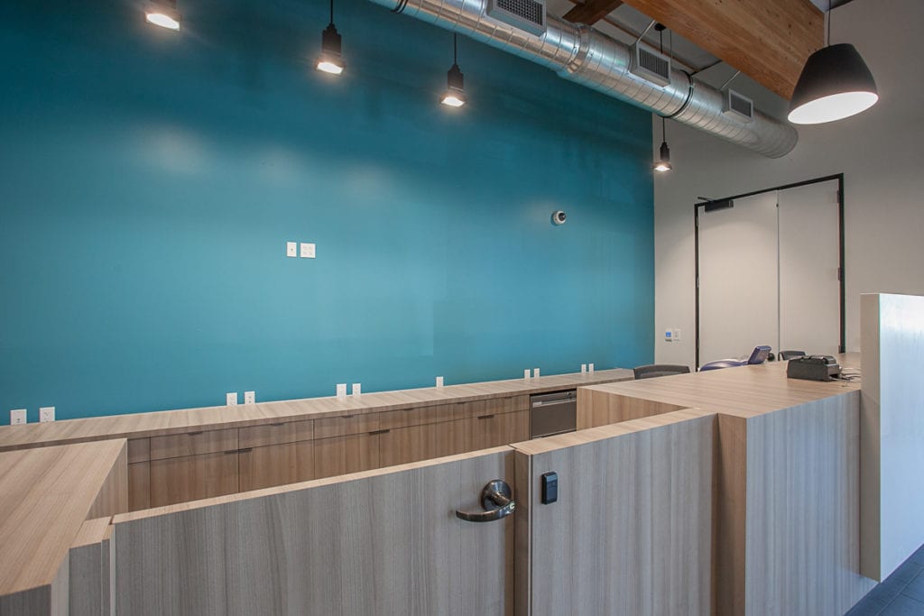 Bank lobby with grey desks and light blue wall