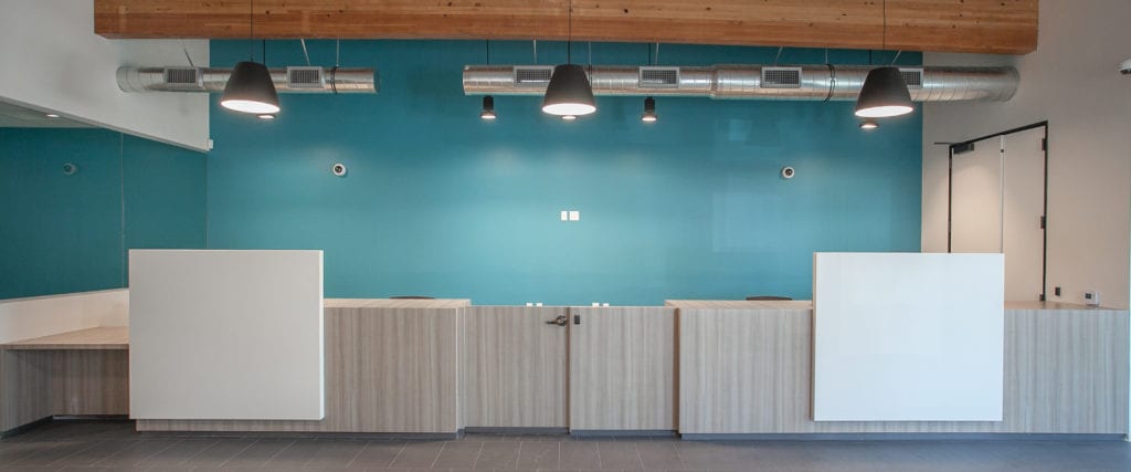 Grey Bank teller desks with blue wall